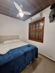 a bedroom with a bed and a ceiling fan at Suítes Pitangueiras - POUSADA FRENTE MAR in Guarujá