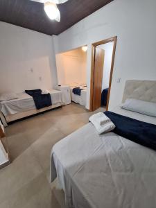 a large room with two beds and a mirror at Suítes Pitangueiras - POUSADA FRENTE MAR in Guarujá +5 photos
