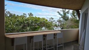 a balcony with a view of trees and bushes at Le chant des vagues in Saint-Philippe