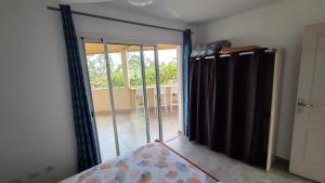 a room with a sliding glass door to a balcony at Le chant des vagues in Saint-Philippe