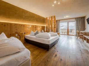 a large bedroom with two beds and a balcony at Hotel Elisabeth Panorama in Antermoia +71 photos