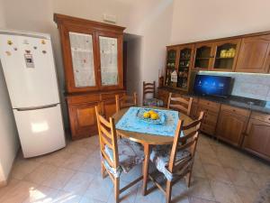 a kitchen with a table and a white refrigerator at Casa Gelso Rosso in Leni