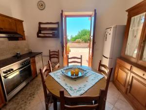 a kitchen with a table with a bowl of fruit on it at Casa Gelso Rosso in Leni