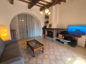 a living room with a couch and a tv at Casa Gelso Rosso in Leni +2 photos