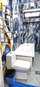 a bathroom with a white toilet and a sink at ARZON Mehmonxona in Tashkent +154 photos