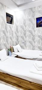 two beds in a room with a wall at ARZON Mehmonxona in Tashkent