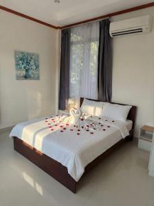 a bedroom with a bed with red roses on it at Srithanu sea Villa in Srithanu