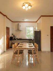 a kitchen with a wooden table and chairs at Srithanu sea Villa in Srithanu