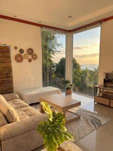 a living room with a couch and a table at Srithanu sea Villa in Srithanu
