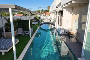 a swimming pool with a bridge in a building at אחוזת מיא - סוויטות בוטיק על המים in Goren +31 photos