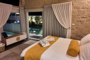 a bedroom with a large bed with towels on it at אחוזת מיא - סוויטות בוטיק על המים in Goren