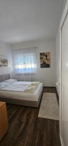 a bedroom with a large bed and a window at Apartman FIKA in Prijepolje