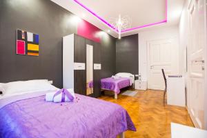 a bedroom with two beds with purple sheets at Apartment Center Four stars in Zagreb