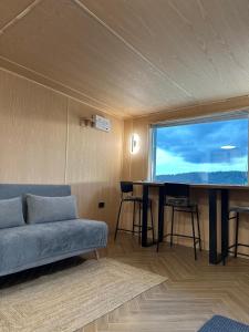 a living room with a couch and a large window at Fanar Chalet in Glodu