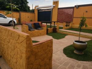 a patio with a retaining wall and a potted plant at Florida Palace Hostal in Samaipata