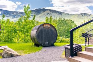 a wooden barrel sitting on the grass with mountains in the background at Breathtaking Views Near Lake Placid and Whiteface in Wilmington