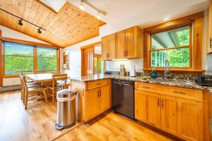 a kitchen with wooden cabinets and a dining table at Breathtaking Views Near Lake Placid and Whiteface in Wilmington