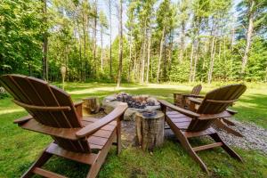 three chairs around a fire pit in a yard at Adirondack Retreat Near Whiteface and Lake Placid in Wilmington