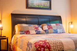 a bedroom with a bed with a quilt on it at Adirondack Retreat Near Whiteface and Lake Placid in Wilmington