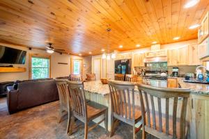 a kitchen with wooden ceilings and a bar with bar stools at Adirondack Retreat Near Whiteface and Lake Placid in Wilmington