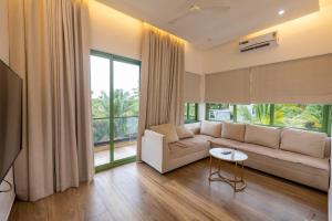 a living room with a couch and a large window at Luxury 3BHK Villa with Private Pool & PS5 in North in Socorro