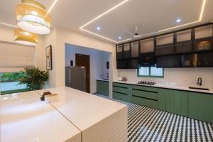 a kitchen with green cabinets and a white counter top at Luxury 3BHK Villa with Private Pool & PS5 in North in Socorro