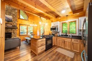 a log cabin kitchen with wooden cabinets and a stove at Luxury ADK Retreat Near Whiteface, Lake Placid in Jay +59 photos