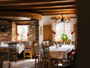 a dining room with white tables and chairs and windows at Alpenhotel Ernberg in Reutte