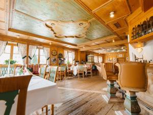 a restaurant with tables and chairs and a ceiling at Alpenhotel Ernberg in Reutte