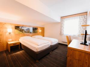 a bedroom with a large bed and a window at Alpenhotel Ernberg in Reutte +48 photos