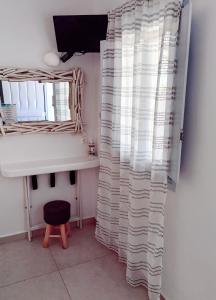 a bathroom with a mirror and a desk and a window at Palio Karnagio Παλιό Καρνάγιο in Koufonisia