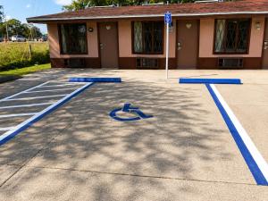 a parking lot with blue handicapped signs in front of a building at Sunrise Inn - Bradenton in Bradenton +8 photos