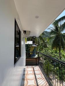 a balcony with a view of a palm tree at The LineUp Surf House Pacifico in San Isidro