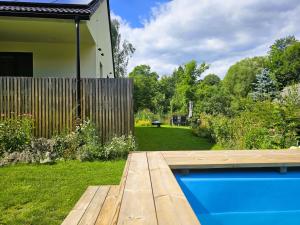 a backyard with a wooden deck and a swimming pool at Apartmán v tichu in Teplice nad Metují