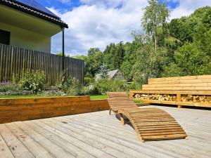 two wooden benches sitting on a wooden deck at Apartmán v tichu in Teplice nad Metují