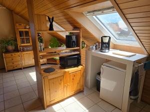 a kitchen with a counter with a microwave and a window at Ferienwohnung Auf der Warthe in Florstadt
