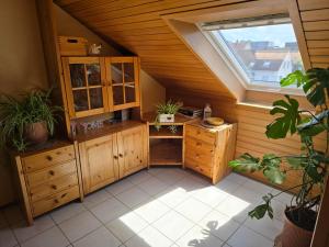 an attic room with wooden cabinets and a window at Ferienwohnung Auf der Warthe in Florstadt