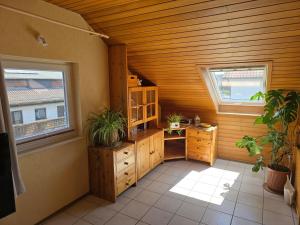 a kitchen with wooden walls and two windows at Ferienwohnung Auf der Warthe in Florstadt