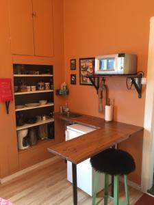 a kitchen with a table and a microwave on a counter at Hen stasjon Venteværelset in Hen