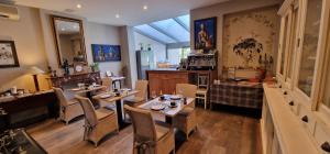 a restaurant with tables and chairs in a room at B&B Villa Des Raisins in Bruges