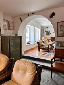 a living room with an archway with a couch and chairs at Hotel La Meridiana in Madesimo
