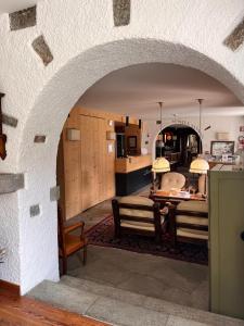 an archway in a kitchen with a table and chairs at Hotel La Meridiana in Madesimo +40 photos