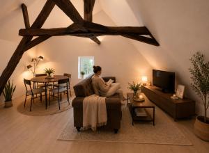 a woman sitting in a chair in a living room at appartement de la voie verte in Hauterive