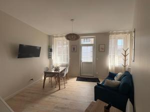 a living room with a couch and a table at Le Petit Bleu - Charming House in Yport