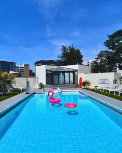 a swimming pool with two pink flamingos in it at Hotel Palladia in Toulouse