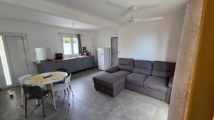 a living room with a couch and a table at le Chant des vagues 1 in Saint-Philippe