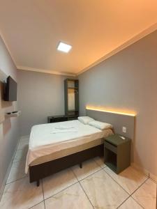 a small bedroom with a bed and a television at Du Vale Hotel in Tomé-Açu +14 photos