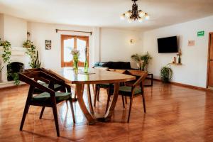 a living room with a wooden table and chairs at Che San Cristobal de las Casas Hostel in San Cristóbal de Las Casas