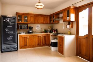 a kitchen with wooden cabinets and a black and white refrigerator at Che San Cristobal de las Casas Hostel in San Cristóbal de Las Casas