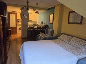 a bedroom with a white bed and a dining room at Apartamento Rural Felechosa in Felechosa